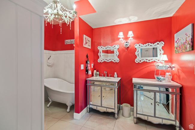 Bathroom featuring tile patterned floors, vanity, a tub, and an inviting chandelier | Image 66