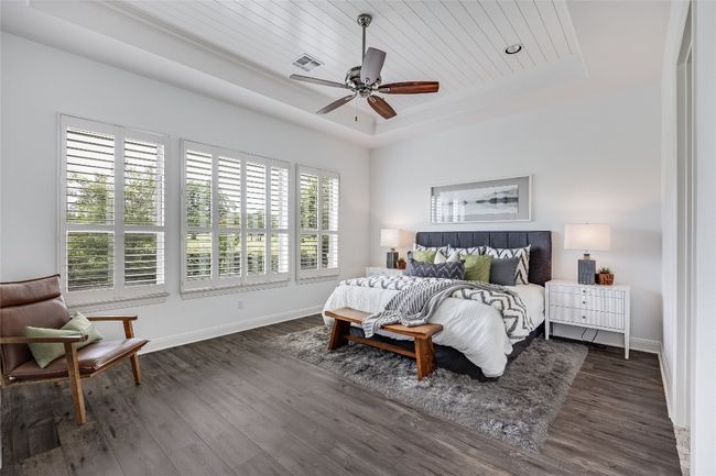 Bedroom with a raised ceiling, wood finished floors, wooden ceiling, and a ceiling fan | Image 19