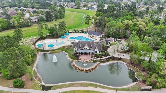 Aerial view of the elegant Clubhouse and pool in The Falls at Imperial Oaks. This community hub features a resort-style pool, splash pad, shaded cabanas, and a tranquil pond with fountains—offering residents the perfect blend of recreation and relaxation. | Image 45