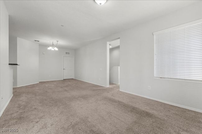 Unfurnished room featuring a chandelier and light carpet | Image 21