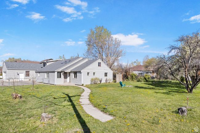 Rear view of property with a patio area, a shingled roof, fence, and a lawn | Image 42