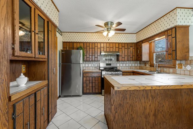 It also includes a spacious peninsula counter, in-floor heating for added comfort during cooler months, and a buffet counter with surrounding cabinetry for additional organization and storage. | Image 7