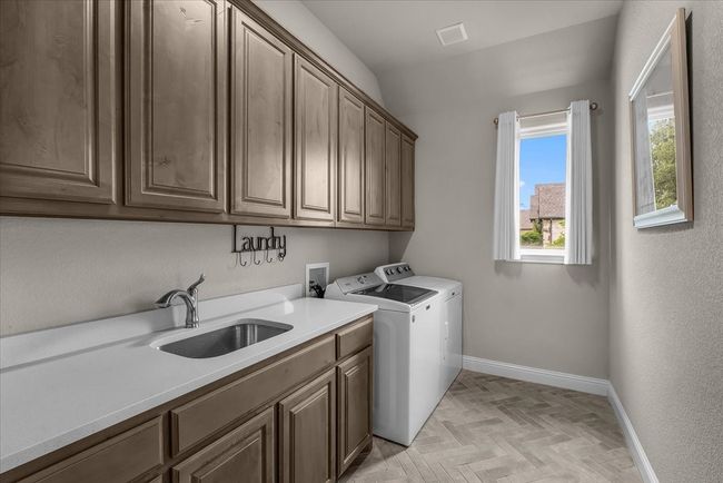 Utility room featuring built-in cabinets & plenty of natural light | Image 17