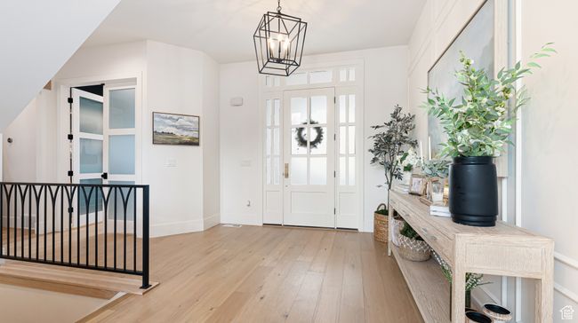 Entryway with light wood-type flooring, baseboards, and a notable chandelier | Image 7