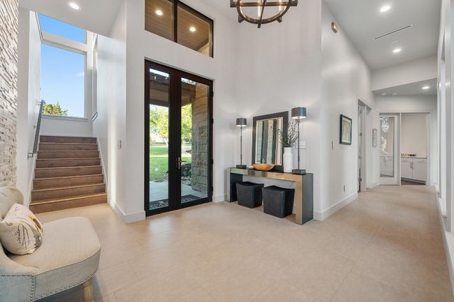 Tiled entryway featuring stairs, french doors, a high ceiling, and baseboards | Image 4