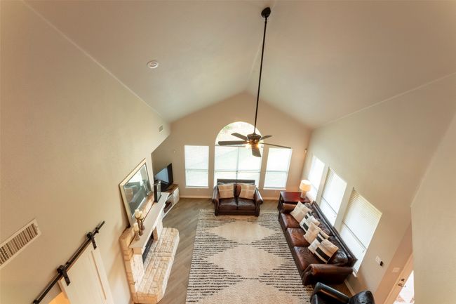 Living area featuring high vaulted ceiling, plenty of natural light, ceiling fan, and wood finished floors | Image 27