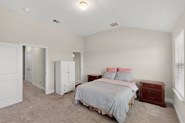 Bedroom featuring lofted ceiling and light carpet | Image 17
