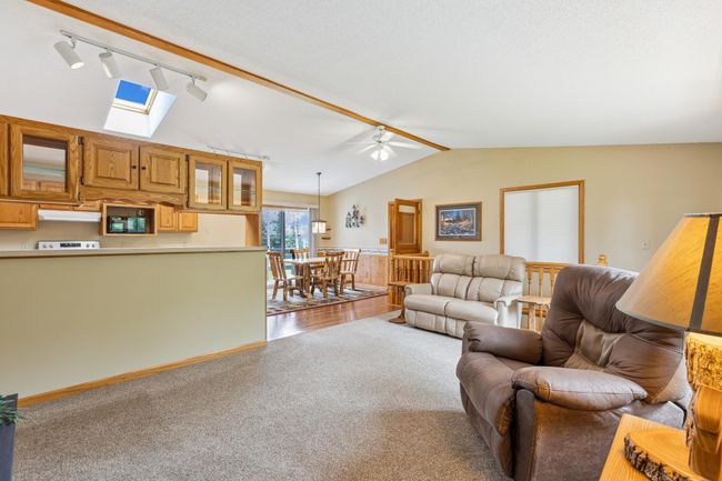 Open concept main level living shows off plush carpet and wood flooring | Image 13