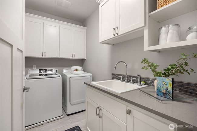 Large spacious laundry room with a sink, folding counter, and lots of storage. | Image 29