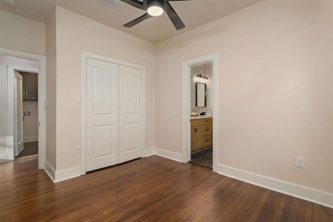 An alternate view of this spacious bedroom showcases the restored original hardwoods floors, spacious double-door closet, and direct access to the convenient bathroom. | Image 24