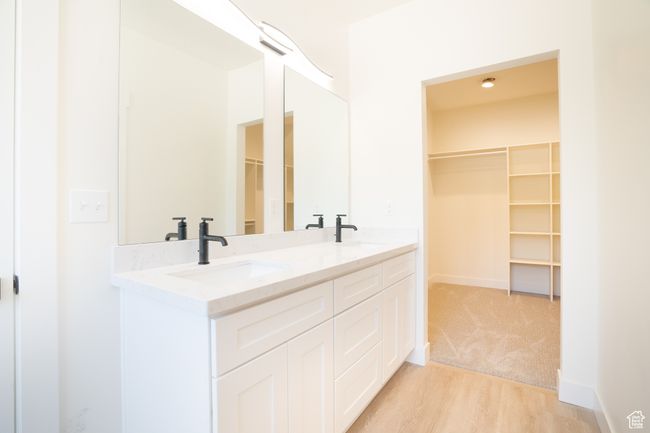 Bathroom featuring double vanity, wood finished floors, and a walk in closet | Image 15