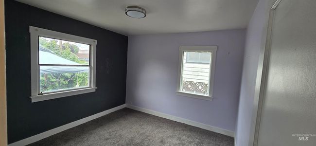 Unfurnished room featuring dark carpet and baseboards | Image 9