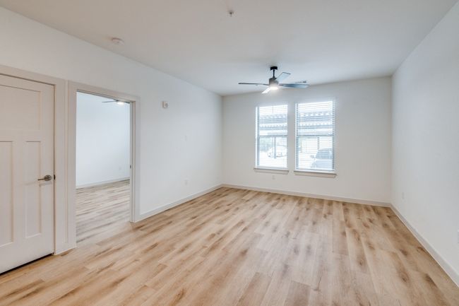 Empty room featuring light wood-style floors, baseboards, and ceiling fan | Image 11