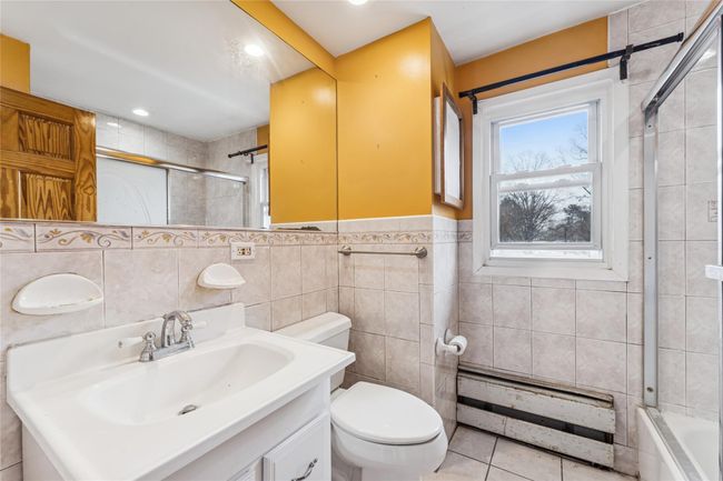 Full bath featuring tile walls, toilet, tile patterned floors, and vanity | Image 11