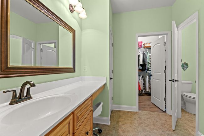 Bathroom with baseboards, toilet, tile patterned floors, vanity, and a spacious closet | Image 20