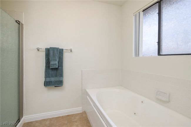 Full bath with a tub with jets, tile patterned floors, and an enclosed shower | Image 12