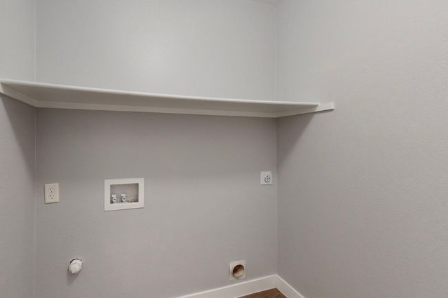 Clothes washing area with hookup for an electric dryer, baseboards, hookup for a washing machine, wood finished floors, and laundry area | Image 16