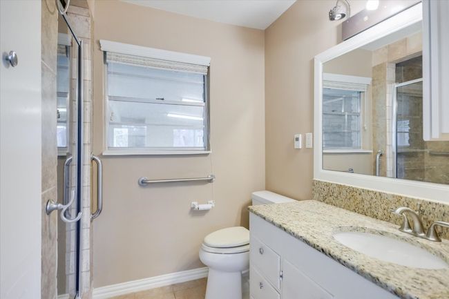 Updated bathroom with a granite countertop and upgraded tiled shower. | Image 24