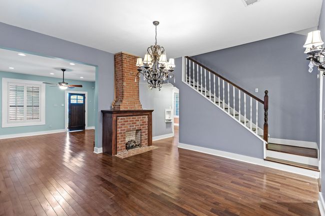 Unfurnished living room featuring a chandelier, stairway, hardwood / wood-style flooring, ceiling fan, and recessed lighting | Image 16