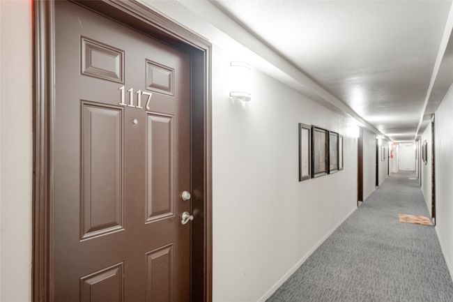 Hall with light colored carpet and baseboards | Image 19