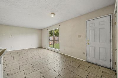 Entryway featuring light tile patterned flooring and a textured ceiling | Image 3