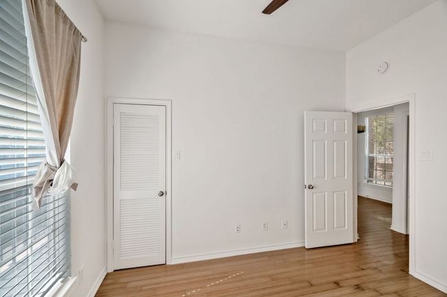 Unfurnished bedroom with light wood-type flooring, a high ceiling, baseboards, and ceiling fan | Image 13