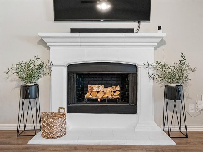 Details featuring a fireplace with raised hearth, wood finished floors, and baseboards | Image 12