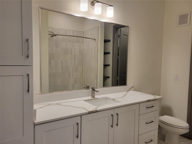 Bathroom with toilet, walk in shower, vanity, and visible vents | Image 16