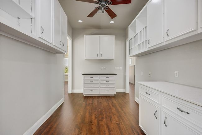 Kitchen with open shelves, white cabinets, ceiling fan, dark wood finished floors, and baseboards | Image 27