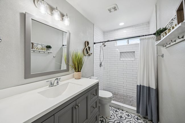 Updated full bathroom featuring vanity, tiled shower, and tile patterned floors | Image 18