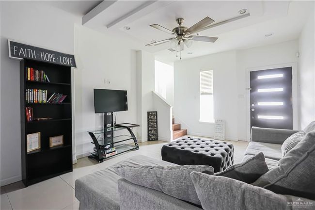 Living room featuring light tile patterned floors, recessed lighting, ceiling fan, baseboards, and stairs | Image 12