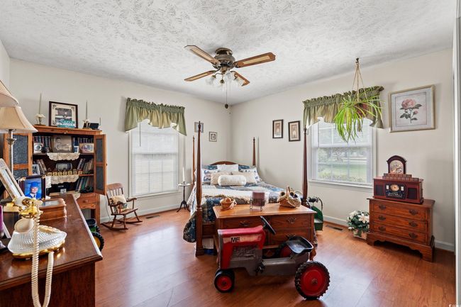 Bedroom featuring baseboards, wood finished floors, and a textured ceiling | Image 21
