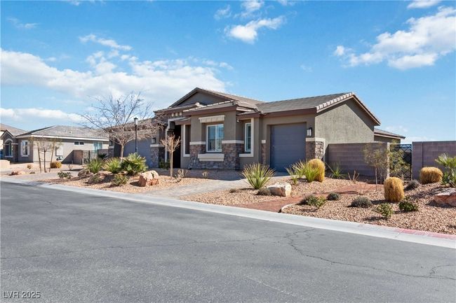 View of front of house with a garage, stone siding, fence, and stucco siding | Image 6