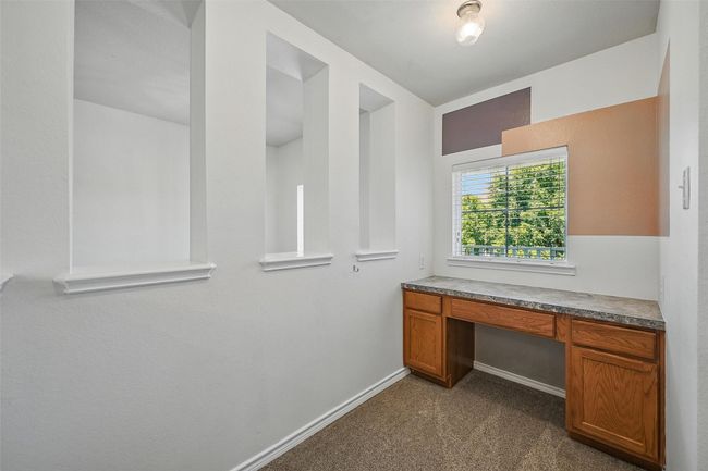 Unfurnished office featuring built in study area, dark carpet, and baseboards | Image 37