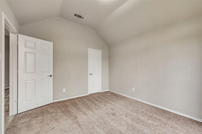 Unfurnished bedroom featuring lofted ceiling and carpet | Image 9