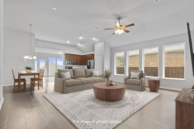 Living room with lofted ceiling, a ceiling fan, light wood-style floors, a chandelier, and baseboards | Image 10