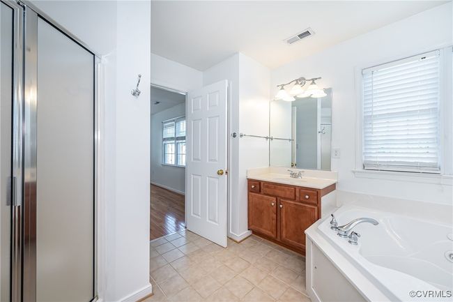 Bathroom with vanity, a garden tub, tile patterned floors, and a stall shower | Image 23