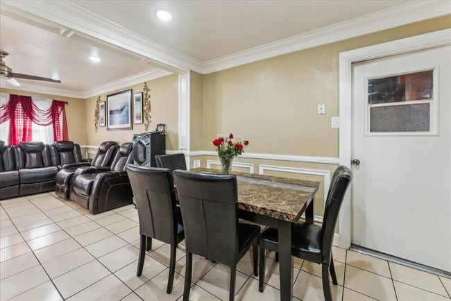 Dining area with ornamental molding and light tile patterned floors | Image 21