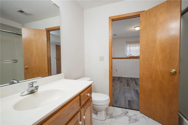 Bathroom featuring toilet, vanity, a shower with shower door, and marble finish floors | Image 29