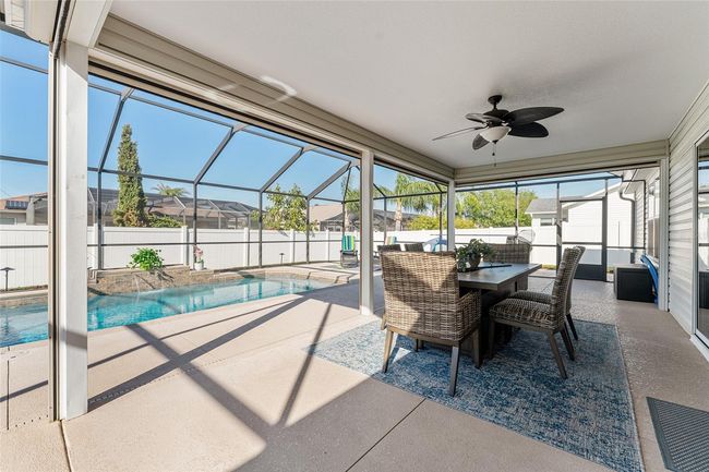 Dine alfresco or relax and enjoy the waterfall pool from the 220 SF covered lanai in 1200 sf screened patio. | Image 27