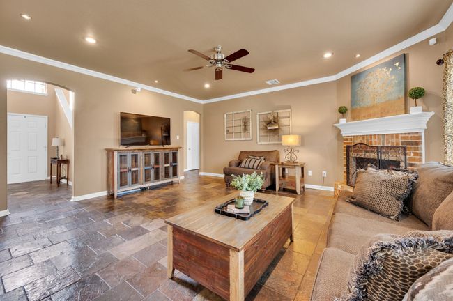 Living room featuring arched walkways, ornamental molding, recessed lighting, stone tile flooring, and a ceiling fan | Image 8