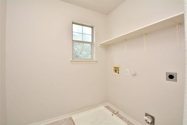 Laundry area with electric dryer hookup, hookup for a gas dryer, hookup for a washing machine, and baseboards | Image 15
