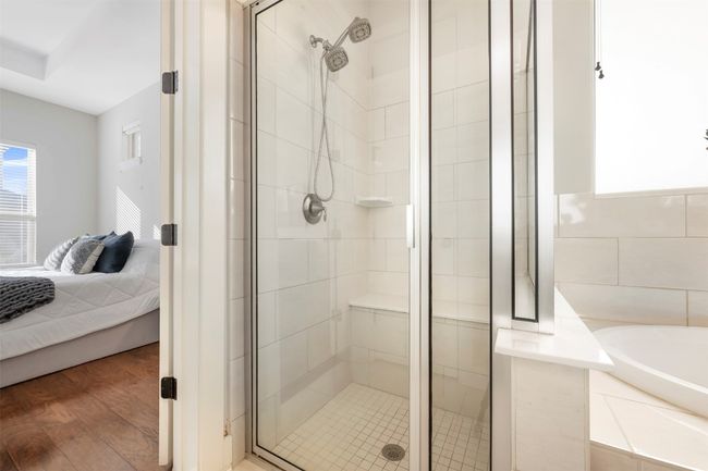 Bathroom with ensuite bathroom, a stall shower, a garden tub, and wood finished floors | Image 15