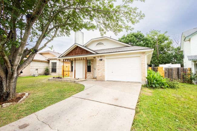 View of front facade featuring brick siding, an attached garage, driveway, a chimney, and roof with shingles | Image 4