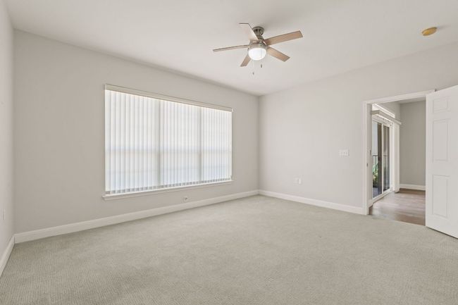 Carpeted empty room featuring baseboards and a ceiling fan | Image 19