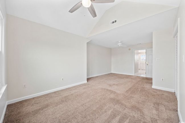 Spare room with ceiling fan, carpet flooring, baseboards, and high vaulted ceiling | Image 25