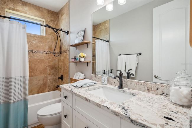 Travertine-tiled bathroom with tub/shower combo on 3rd floor. | Image 70