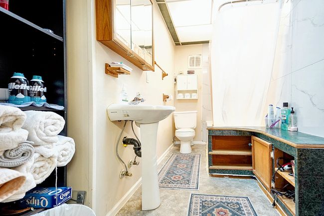 Bathroom featuring toilet, baseboards, and curtained shower | Image 13
