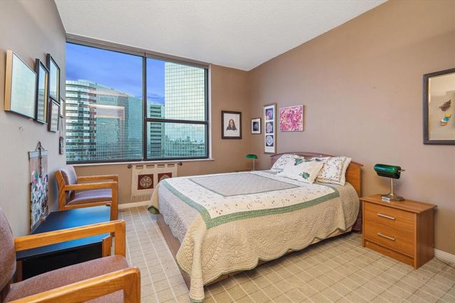 This spacious secondary bedroom boasts beautiful city views, creating a serene and inviting space. | Image 22