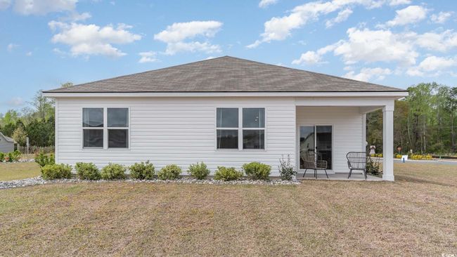 Rear view of house with roof with shingles, a patio area, and a lawn | Image 24